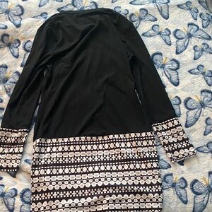 Black midi dress with unique design on bottom and arm cuffs for any occasion